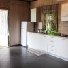 Cucina moderna con pavimento scuro e frigorifero bianco.