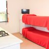 Interno con letti a castello rossi e angolo cottura con fornelli e finestra.