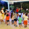 Gruppo di bambini si diverte mentre ballano insieme all'aperto di sera.