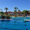 Piscina con palme e gazebo rosso.
