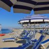 Spiaggia con ombrelloni a strisce blu e bianche.