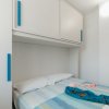 Letto matrimoniale con lenzuola a righe e armadio sopra.