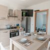 Cucina moderna con tavolo apparecchiato e vista su camera da letto.