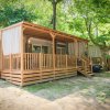 Una moderna casa mobile con veranda in legno immersa nel verde.