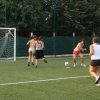 Giocatrici di calcio in un campo all'aperto vicino alla rete.
