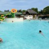 Piscina con scivoli, bambini e una decorazione a fiore.