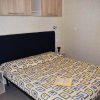 Letto matrimoniale con copriletto geometrico.
