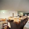 Sala da pranzo vuota con tavoli apparecchiati.