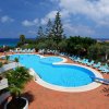 Piscina all'aperto con lettini blu e vista mare.