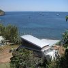 Un camper vicino al mare con vista su barche e scogli.