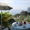 Tavolo all'aperto con colazione vista mare e torre in lontananza.