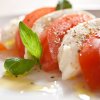 Insalata caprese con pomodoro, mozzarella e basilico, condita con olio d'oliva.
