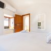 Stanza con letto, porta aperta e finestra soleggiata.