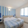 Una camera da letto con pareti a strisce blu e bianche, letto matrimoniale e finestra.
