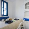 Sala da pranzo con tavolo apparecchiato, credenza bianca e blu, e finestra con cornice blu.