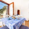 Tavolo apparecchiato con tovaglia blu e vista su paesaggio montuoso attraverso la finestra.