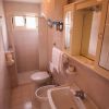Bagno stretto con doccia e lavandino.
