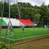 Campo da calcetto recintato con giocatori.