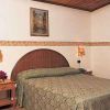 Una camera da letto con un letto matrimoniale, armadio, comodino e tende verdi.
