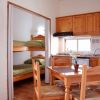 Cucina con tavolo in legno, letti a castello adiacenti.