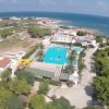 Vista aerea di un complesso con piscina vicino al mare.