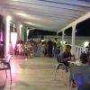 Una terrazza ristorante con persone sedute a tavoli sotto luci soffuse.