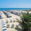 Spiaggia con ombrelloni e lettini allineati, vista mare.