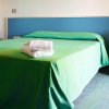 Letto con copriletto verde e asciugamani.