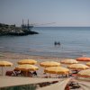 Spiaggia con ombrelloni gialli e mare calmo.