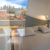Camera con letto matrimoniale e vista su case rosse all'esterno.