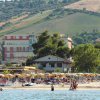 Spiaggia affollata con ombrelloni e mare.