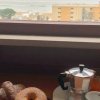 Colazione con vista su palazzi e mare dalla finestra.