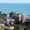 Vista su edifici e mare, circondati da alberi.