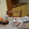Tavolo da colazione con giornali, caffè e succo d'arancia.