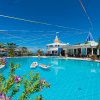 Piscina con persone e nastri colorati nel cielo.