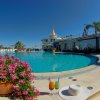 Piscina con fiori, bibite e cappello in primo piano.