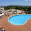 Piscina circondata da lettini su terrazza con vista panoramica.