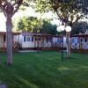 Bungalow con verande, alberi e prato curato.