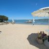 Spiaggia con ombrelloni e persona che riposa.