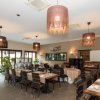 Ristorante elegante con tavoli apparecchiati e lampade pendenti.