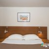 Camera con letto matrimoniale, comodini e quadro appeso.