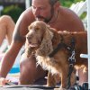 Un uomo con un cane marrone su un telo da spiaggia.