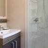 Bagno moderno con lavandino, mobile sottostante, specchio e cabina doccia.