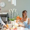 Persone che brindano in una cucina moderna.