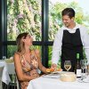 Cliente che riceve un piatto al ristorante da un cameriere sorridente.