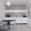 Cucina moderna con tavolo e sedie, illuminazione minimalista.