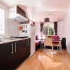 Cucina moderna con zona pranzo e tende scure.