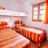 Stanza con letto a castello e letti singoli, copriletto arancioni.