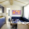 Cucina moderna con mobili blu, tavolo apparecchiato e divano ad angolo.