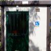 Toilette accessibile con porta verde e segnaletica per disabili.